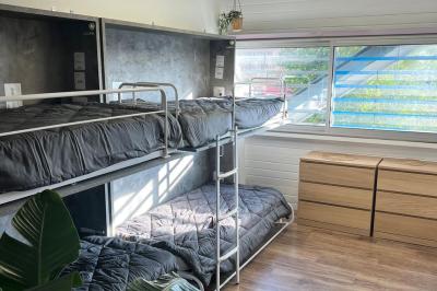 Vue d'un grand salon lumineux avec carrelage beige, cuisine ouverte et baies vitrées donnant sur un jardin.