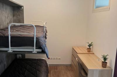 Vue d'un grand salon lumineux avec carrelage beige, cuisine ouverte et baies vitrées donnant sur un jardin.