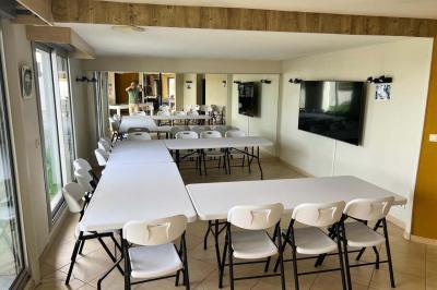 Grande pièce lumineuse avec carrelage beige, cuisine ouverte, baies vitrées donnant sur un jardin avec pelouse.