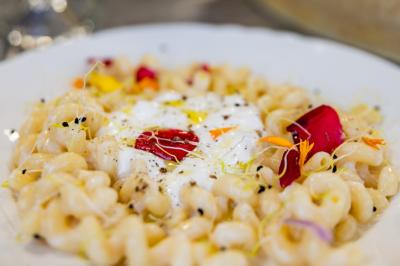 Assiette de tagliatelles fraîches avec sauce tomate, morceaux de viande, persil frais et croûton garni de lard grillé.