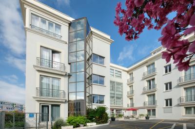 Salle de réunion avec des chaises disposées en cercle, une table basse au centre et un écran mural.
