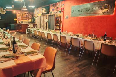 Table garnie de verrines, brochettes de fruits frais et plateaux de donuts colorés sur une nappe décorative.