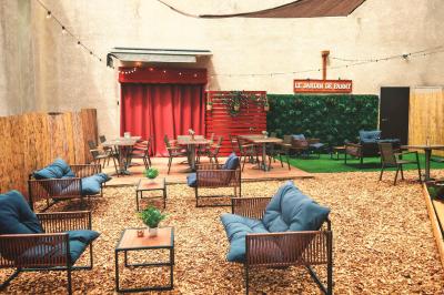 Table garnie de verrines, brochettes de fruits frais et plateaux de donuts colorés sur une nappe décorative.