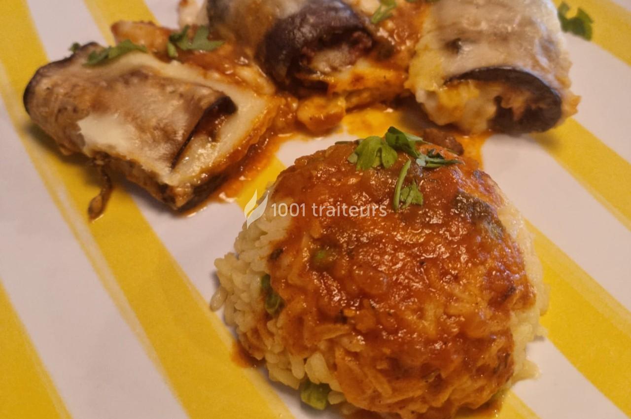 Assiette contenant des roulés d'aubergines gratinés et une portion de riz nappée de sauce tomate, décorée de persil.
