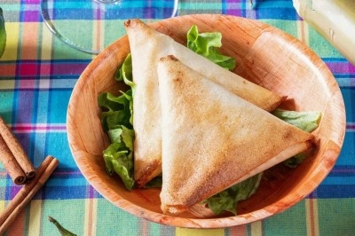 Assiette composée de rillettes de poisson servies dans des coques de noix de coco, accompagnées d'avocat et de crudités.