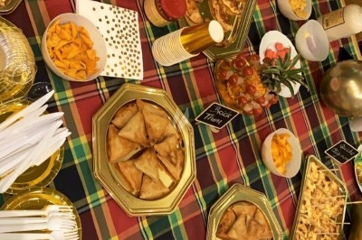 Assiette composée de rillettes de poisson servies dans des coques de noix de coco, accompagnées d'avocat et de crudités.