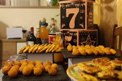 Table décorée avec des amuse-bouches, des boissons et des cubes numérotés en arrière-plan pour une fête.