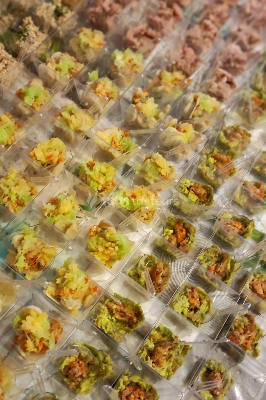 Plateau de verrines variées alignées, contenant des préparations colorées à base de légumes, viandes et poissons.