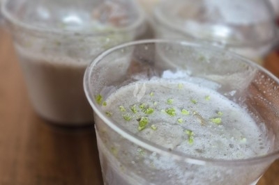 Plateau de viennoiseries, petits pains garnis, fruits de la passion, jus d'orange et boisson chaude dans un gobelet.