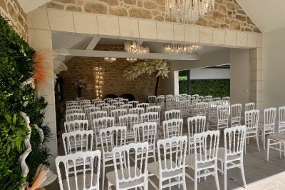 Grande table décorée pour un repas festif, avec nappes en toile de jute, serviettes pliées et centres de table fleuris.