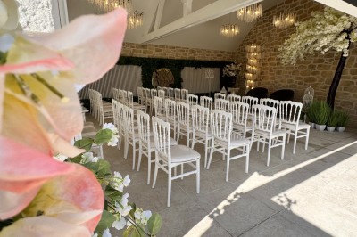 Grande table décorée pour un repas festif, avec nappes en toile de jute, serviettes pliées et centres de table fleuris.
