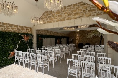 Grande table décorée pour un repas festif, avec nappes en toile de jute, serviettes pliées et centres de table fleuris.