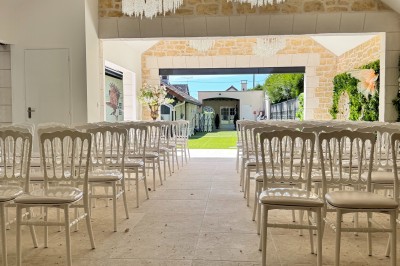 Grande table décorée pour un repas festif, avec nappes en toile de jute, serviettes pliées et centres de table fleuris.