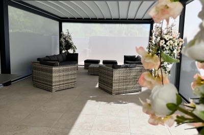Grande table décorée pour un repas festif, avec nappes en toile de jute, serviettes pliées et centres de table fleuris.