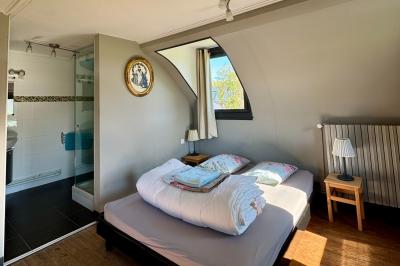 Chaise en bois clair avec dossier croisé et assise en rotin, vue de face sur fond blanc.