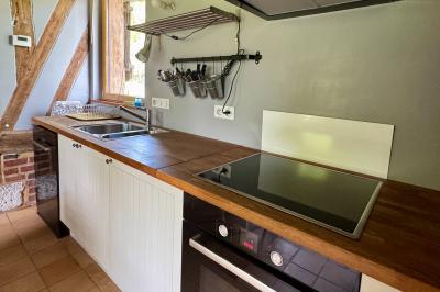 Chaise en bois clair avec dossier croisé et assise en rotin, vue de face sur fond blanc.