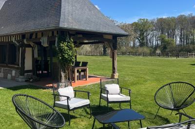Chaise en bois clair avec dossier croisé et assise en rotin, vue de face sur fond blanc.
