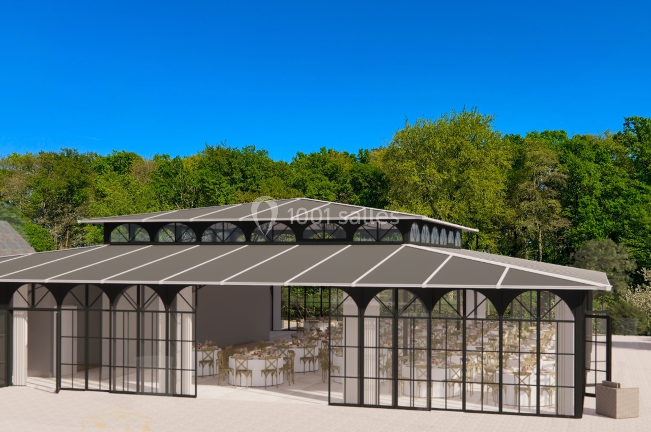 Structure en verre et métal avec toit en pente, entourée de verdure, aménagée pour des événements avec tables dressées.