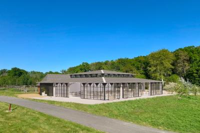 Chaise en bois clair avec dossier croisé et assise en rotin, vue de face sur fond blanc.