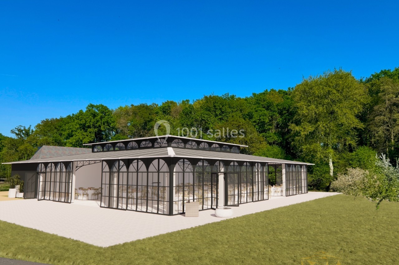 Vue extérieure d'une grande verrière moderne entourée de verdure, avec ciel bleu en arrière-plan.