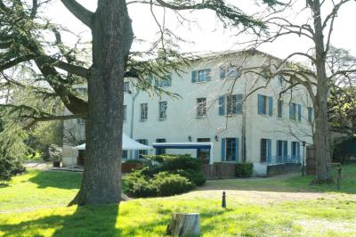Salle avec des tables rondes et rectangulaires recouvertes de nappes blanches, entourées de chaises noires.