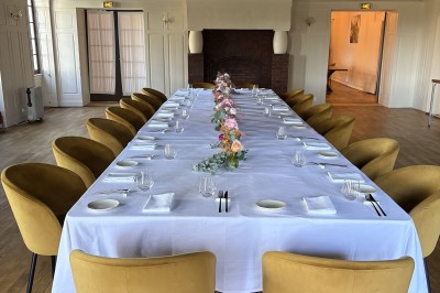 Grande maison blanche à deux étages avec volets bleus, entourée d'arbres et d'un jardin verdoyant.