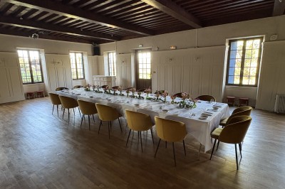 Grande maison blanche à deux étages avec volets bleus, entourée d'arbres et d'un jardin verdoyant.