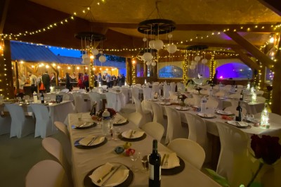 Massif de fleurs violettes au premier plan, terrasse en bois et ciel bleu en arrière-plan.