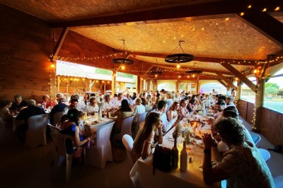 Massif de fleurs violettes au premier plan, terrasse en bois et ciel bleu en arrière-plan.
