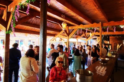 Massif de fleurs violettes au premier plan, terrasse en bois et ciel bleu en arrière-plan.