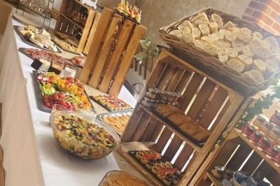 Buffet varié avec pains, fruits, légumes, verrines et autres plats disposés sur des caisses en bois.