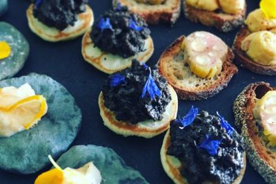 Cheesecake rond avec zeste de citron jaune et vert, sur une base de biscuit spéculoos.