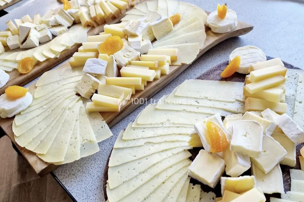 Plateaux de fromages variés disposés sur des planches en bois, avec des tranches et morceaux décorés d'abricots secs.