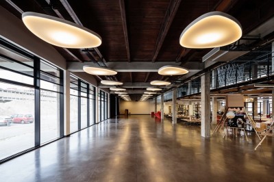 Salle sombre avec deux écrans affichant un paysage désertique, éclairages colorés et mobilier minimaliste.