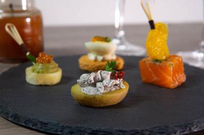 Plateau de bouchées apéritives garnies de mousse rose et décorées de feuilles de persil, disposées sur une grille.