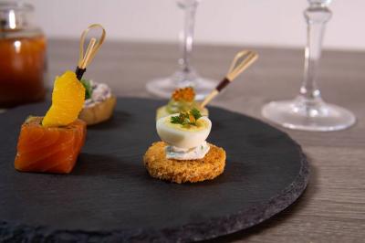 Plateau de bouchées apéritives garnies de mousse rose et décorées de feuilles de persil, disposées sur une grille.