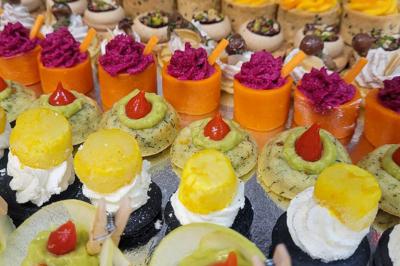 Plateau de bouchées apéritives garnies de mousse rose et décorées de feuilles de persil, disposées sur une grille.