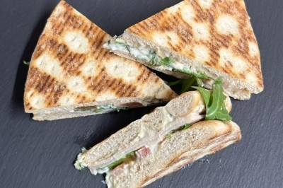 Plateau de bouchées apéritives garnies de mousse rose et décorées de feuilles de persil, disposées sur une grille.