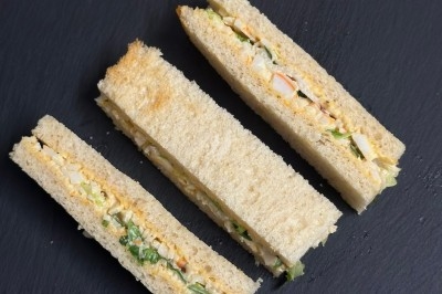 Plateau de bouchées apéritives garnies de mousse rose et décorées de feuilles de persil, disposées sur une grille.