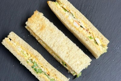 Plateau de bouchées apéritives garnies de mousse rose et décorées de feuilles de persil, disposées sur une grille.