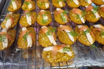 Plateau de bouchées apéritives garnies de mousse rose et décorées de feuilles de persil, disposées sur une grille.