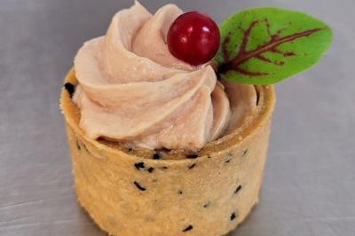 Plateau de bouchées apéritives garnies de mousse rose et décorées de feuilles de persil, disposées sur une grille.