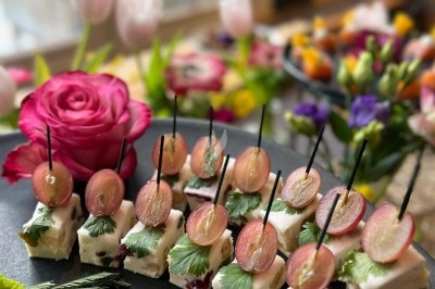 Plateau de bouchées apéritives garnies de mousse rose et décorées de feuilles de persil, disposées sur une grille.