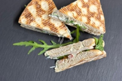 Plateau de bouchées apéritives garnies de mousse rose et décorées de feuilles de persil, disposées sur une grille.