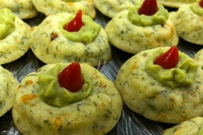 Plateau de bouchées apéritives garnies de mousse rose et décorées de feuilles de persil, disposées sur une grille.