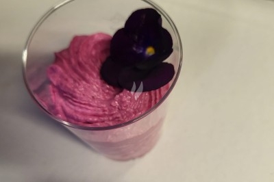 Plateau de bouchées apéritives garnies de mousse rose et décorées de feuilles de persil, disposées sur une grille.