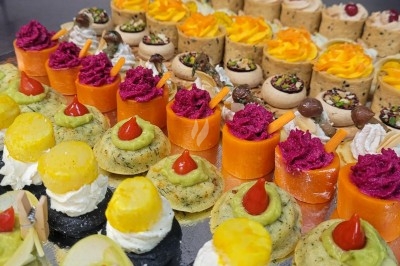 Plateau de bouchées apéritives garnies de mousse rose et décorées de feuilles de persil, disposées sur une grille.