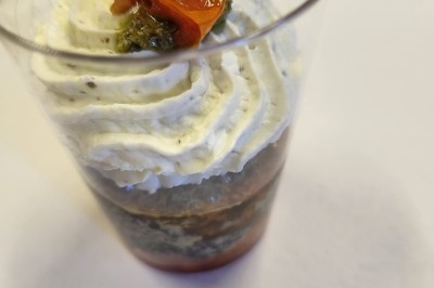 Plateau de bouchées apéritives garnies de mousse rose et décorées de feuilles de persil, disposées sur une grille.