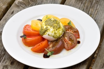 Plateau de bouchées apéritives garnies de mousse rose et décorées de feuilles de persil, disposées sur une grille.