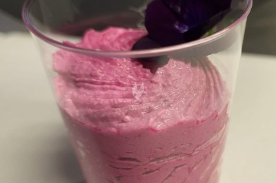 Plateau de bouchées apéritives garnies de mousse rose et décorées de feuilles de persil, disposées sur une grille.